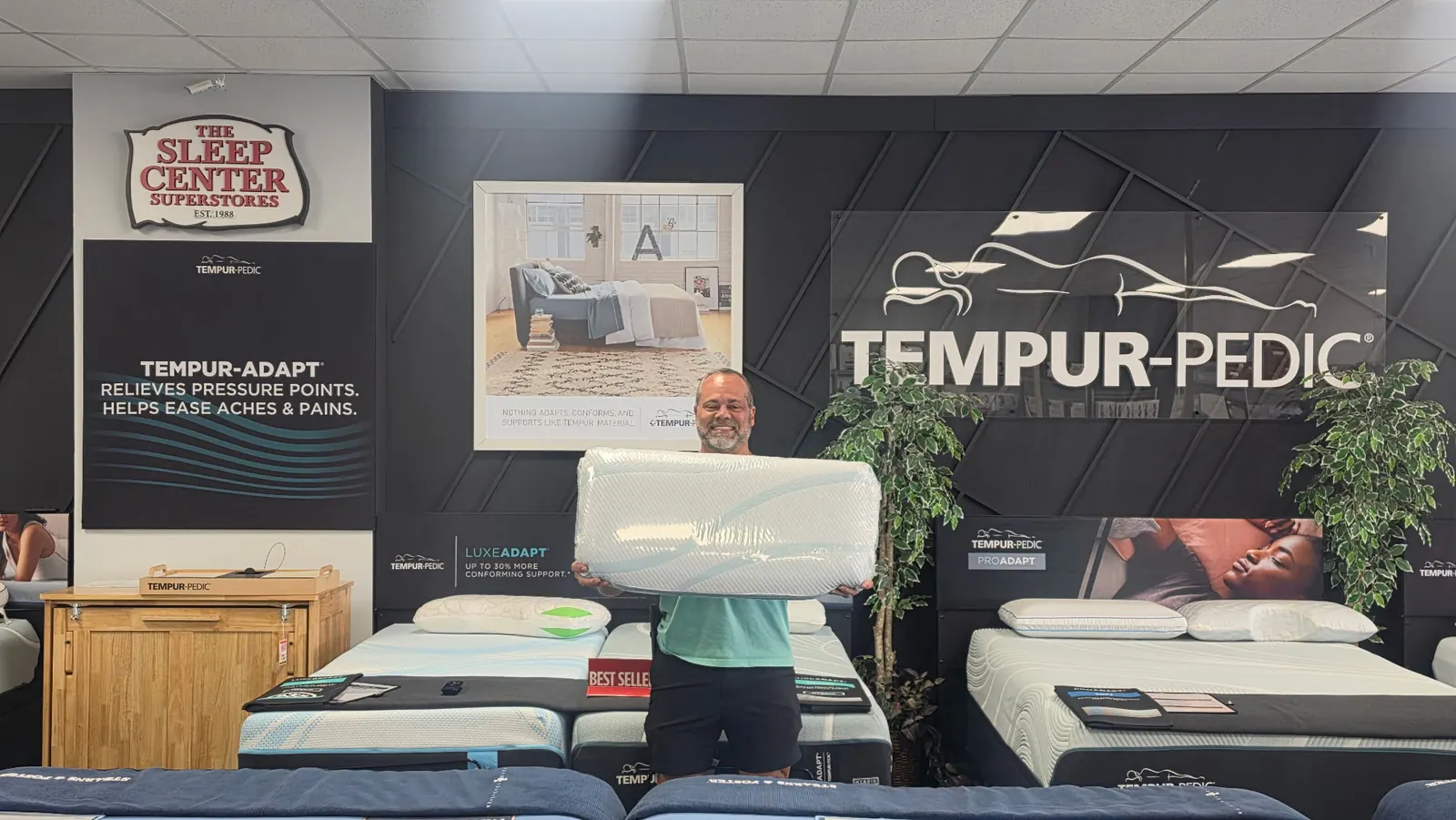 Owner Richard Branham holding a Tempur-Pedic pillow in The Sleep Center showroom