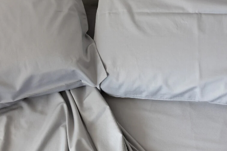 Fresh sheet set on a made bed