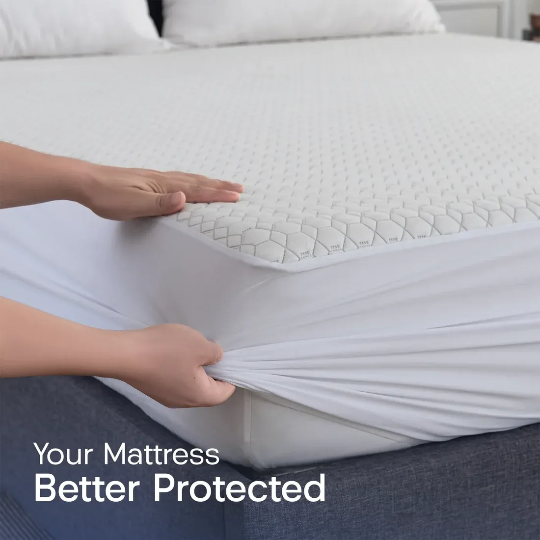 Hands fitting a quilted waterproof mattress protector over a mattress