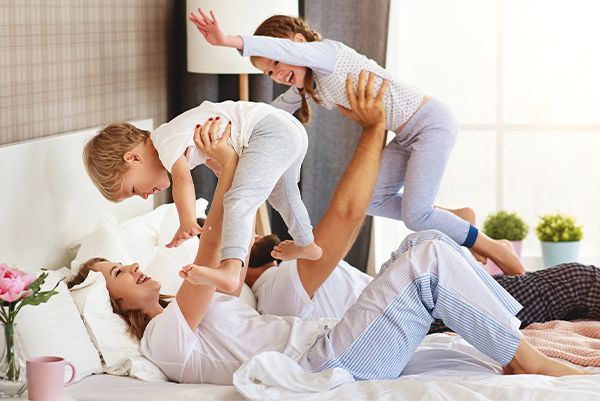 Family playing together on a bed